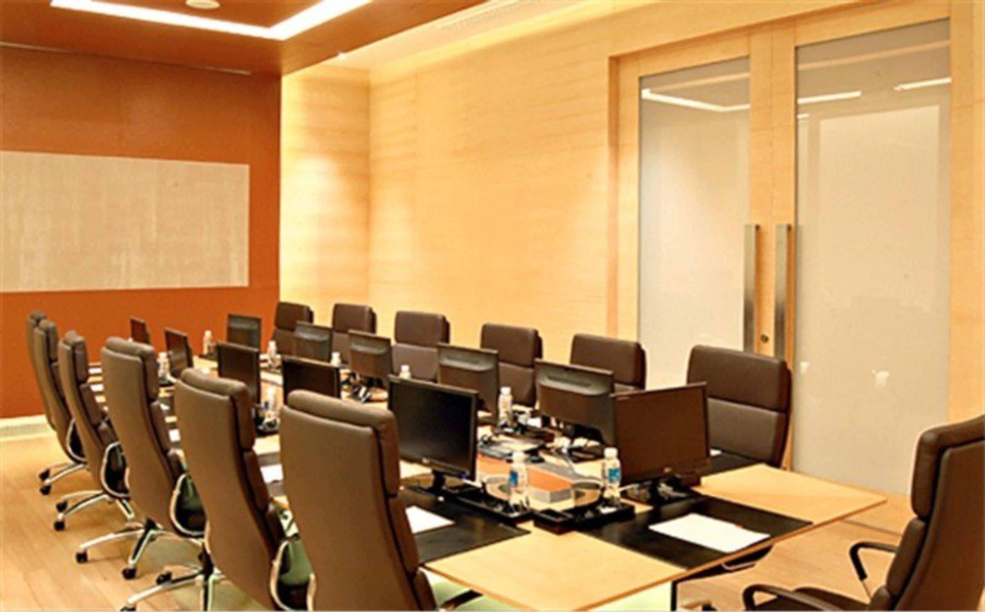 Pathumwan Princess Hotel - Sha Extra Plus Certified Banguecoque Exterior foto The image shows a modern conference room. There are several office chairs arranged around a large table, equipped with desktop monitors at each workspace. The walls have a warm wooden finish, and there is a glass wall that likely leads to an adjacent