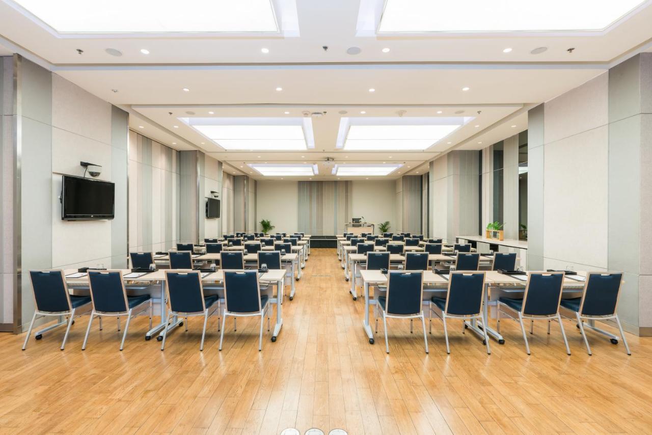 Pathumwan Princess Hotel - Sha Extra Plus Certified Banguecoque Exterior foto The image shows a spacious conference room or meeting space. It features multiple rows of tables and chairs set up for an event, such as a seminar or workshop. The room has a modern design with a wooden floor, large windows, and recessed lighting. A 